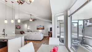 A modern kitchen with a dining area, a large window, and a ceiling fan. - Gilbert Family Home: Games, Private Pool & Patio! (Gilbert)