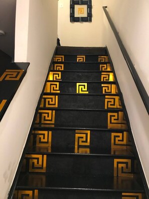 A staircase with black steps and golden geometric patterns.