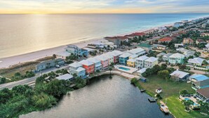 A coastal residential area with colorful houses, a beach, and a body of water. - Beach House - Dreams Come True by PHG (Panama City Beach)