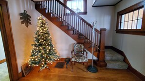 A staircase with wooden railings and a Christmas tree decorated with lights. - This big old charming house Viroqua (Viroqua)