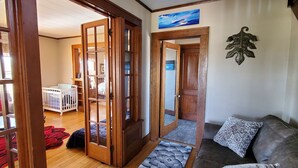 A living room with a brown leather sofa, patterned cushions, a wooden floor, and a red rug. - This big old charming house Viroqua (Viroqua)