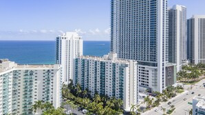 A high-rise hotel with multiple floors, a view of the ocean, and palm trees in the foreground. - Stunning ocean front unit 2/2 with privet beach excess (Hollywood)