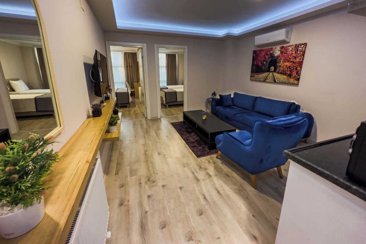 Una sala de estar moderna con un sofá azul, una mesa de centro de madera y un espejo grande.