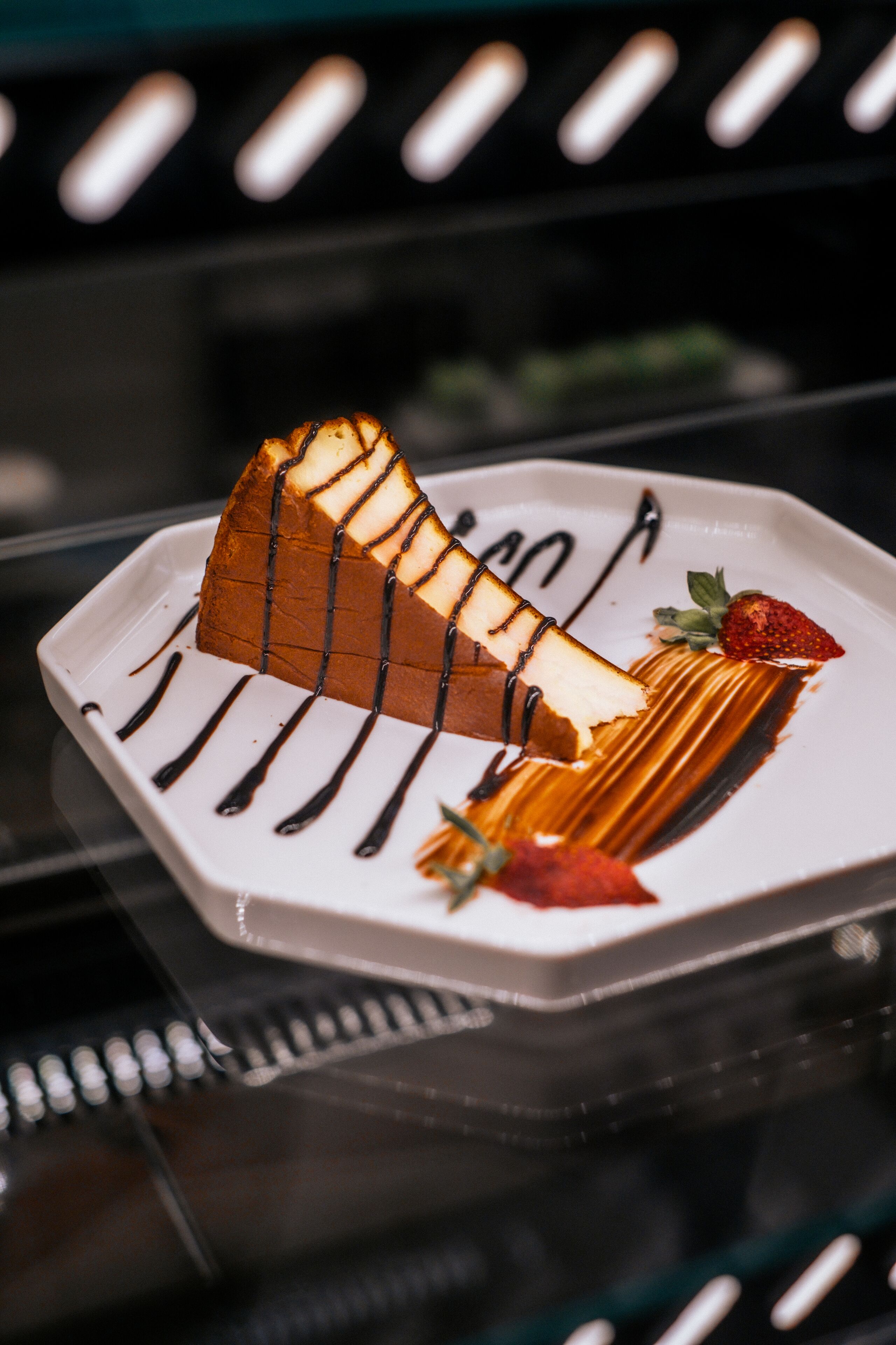 Un dessert su un piatto bianco con glassa al cioccolato e una fragola come decorazione.