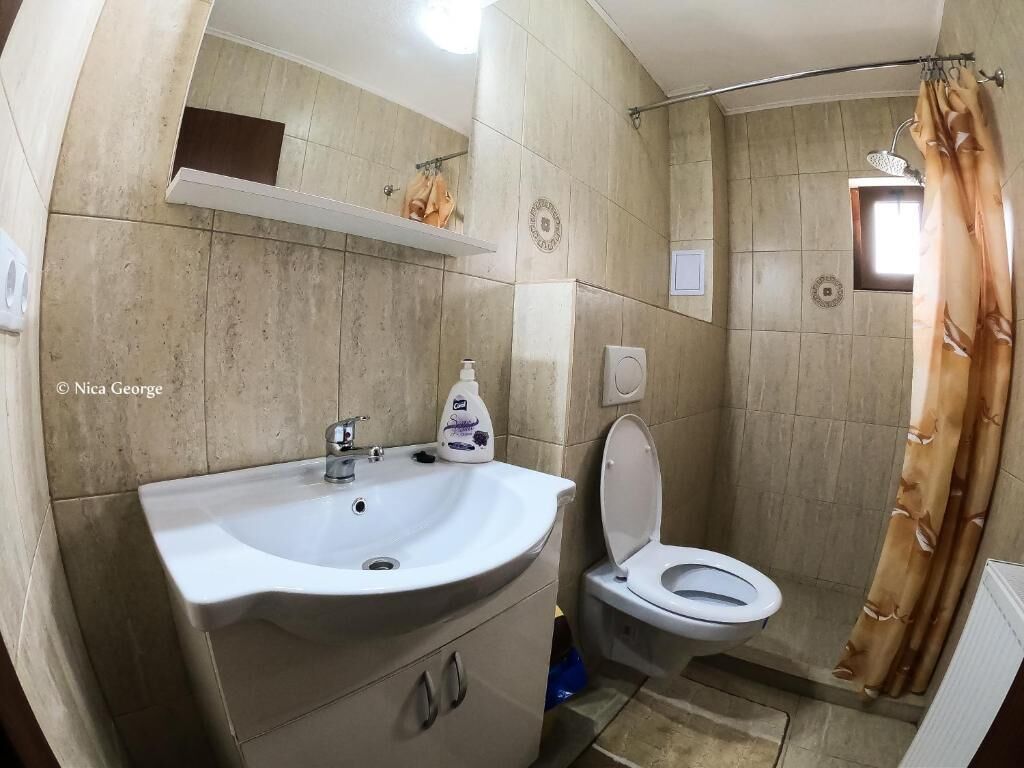 Un baño con lavabo, inodoro y cortina de ducha.
