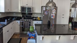 A modern kitchen with white cabinetry, stainless steel appliances, and a central island. - Family home at Rohnert Park (Rohnert Park)