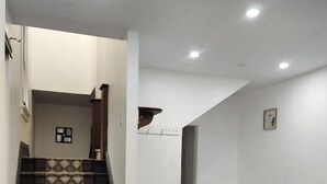 Un intérieur moderne avec un escalier, un parquet en bois foncé et des murs blancs.