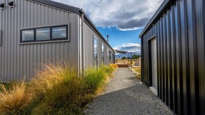 A pathway leading to a row of buildings with large windows and a gravel path. - Southern Stars - FREE WiFi (Twizel)