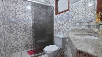 A bathroom with a shower, toilet, and sink.