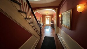 A grand staircase leading to a room with a large framed picture on the wall. - Publick House Hotel Inc. (Chester)