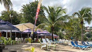 A beachside location with lounge chairs, umbrellas, and a sign for 'Hard Cider'. - Renovated 37m2 studio located 30 meters from Anse à L'âne beach (TROIS ILETS)