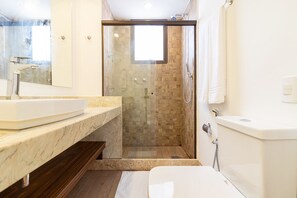 A modern bathroom with a glass-enclosed shower, a marble sink, and a toilet. - Tabas | Moderno apto em Ipanema - RJ | IP0019 (Rio de Janeiro)