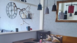 A dining area with a wooden table, two chairs, a mirror, and hanging pendant lights. - Vacation apartment "Bergliebe"  (Germaringen)