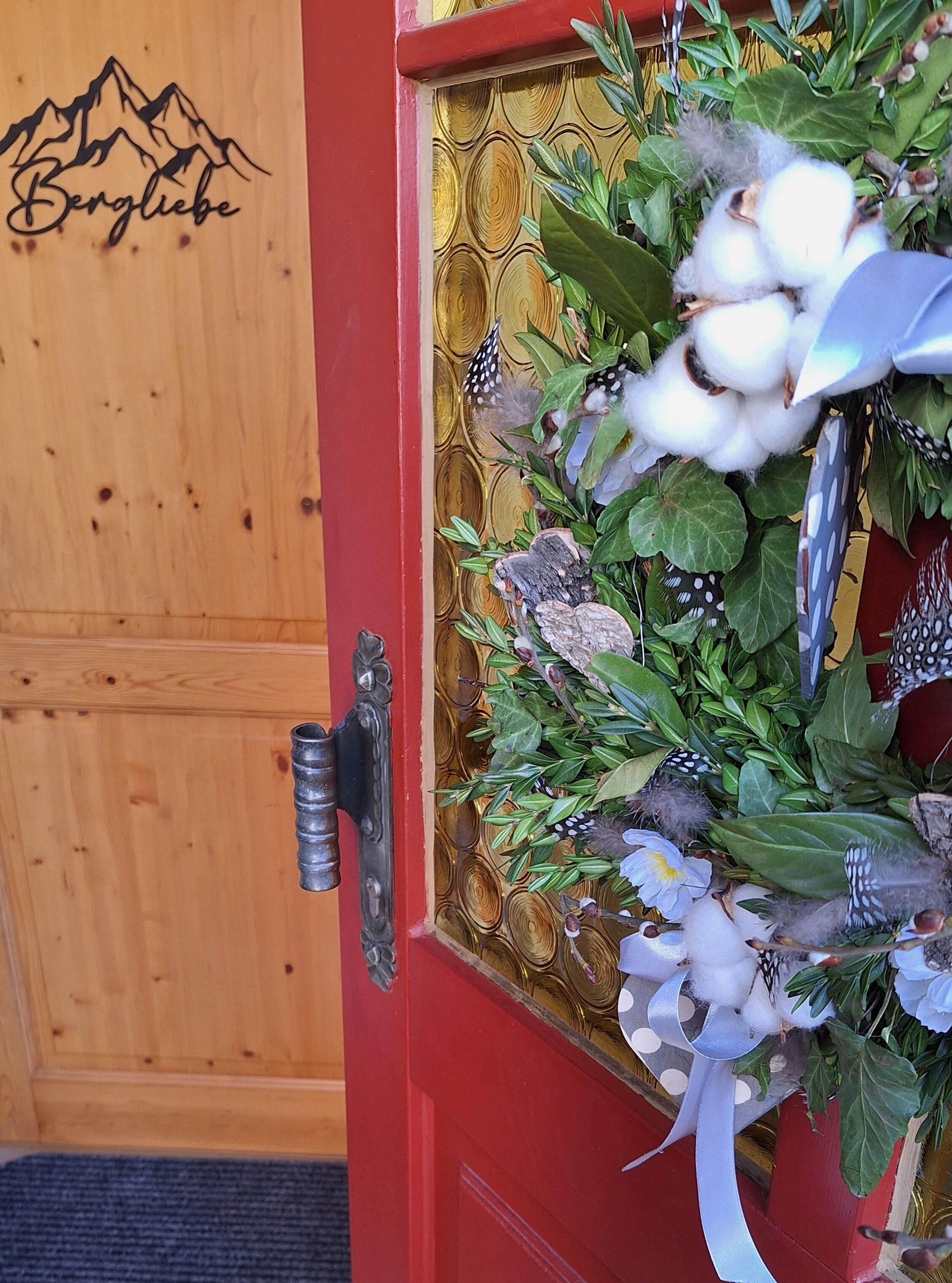 A wooden door with a mountain design and a red door frame.