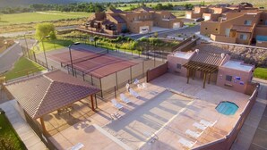 Een resort met een zwembad, een overdekt terras en meerdere gebouwen in woestijnstijl.
