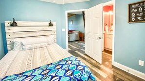 A bedroom with a bed, a ceiling fan, and a wall with a 'Animals of Texas' sign.