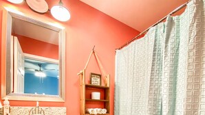 A bathroom with a white toilet, a sink with a mirror, and a shower curtain.