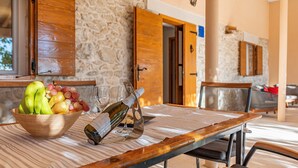 A dining table with a bowl of fruit, wine glasses, and a bottle. - Holiday Home Apios - Three Bedroom Holiday Home with Swimming Pool (Benkovac)