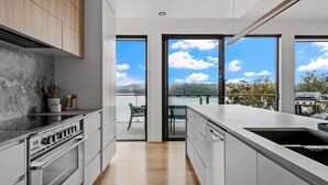 A modern kitchen with a view of a lake and mountains. - Piccolo Segreto Lake Conjola (Lake Conjola)