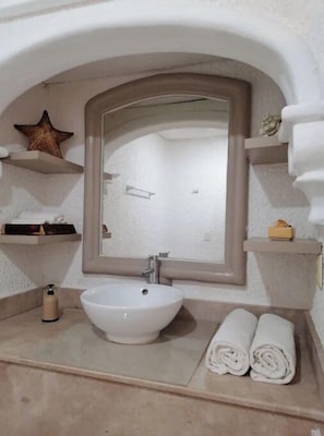 A bathroom with a white sink, a large mirror, and a star decoration on the wall. - Beachfront with amazing view (Cancún)
