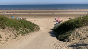 Ein Sandstrand mit Zelten und Menschen.