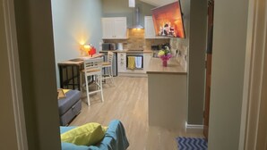 A compact living space with a kitchenette, a dining area, and a sofa.