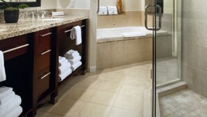 Un baño moderno con ducha de vidrio, un espejo grande y un mueble de tocador con encimera de granito.