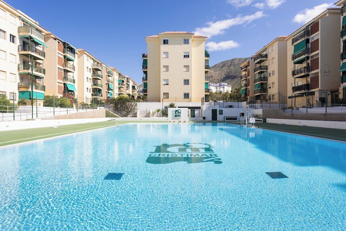 A swimming pool with a building in the background.