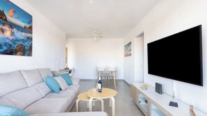 A modern living room with a sofa, coffee table, and TV. - Home2Book Comfy Seaside Apartment Cristimar, Pool (Los Cristianos)