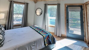 A bedroom with a bed, a ceiling fan, a window, and a door. - Echo Summit Cabin: Hot Tub, 1mi to Sierra at Tahoe (Twin Bridges)
