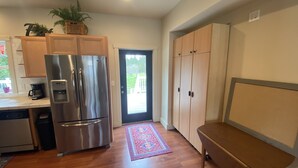A modern kitchen with stainless steel appliances, wooden cabinets, and a large wooden wardrobe. - Charming Gig Harbor Getaway (Gig Harbor)