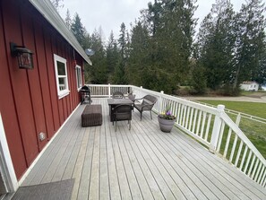 Relax on the deck with a seating area, planter, and grill.