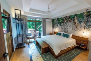 Un dormitorio con una cama grande, un escritorio y vistas al exterior.