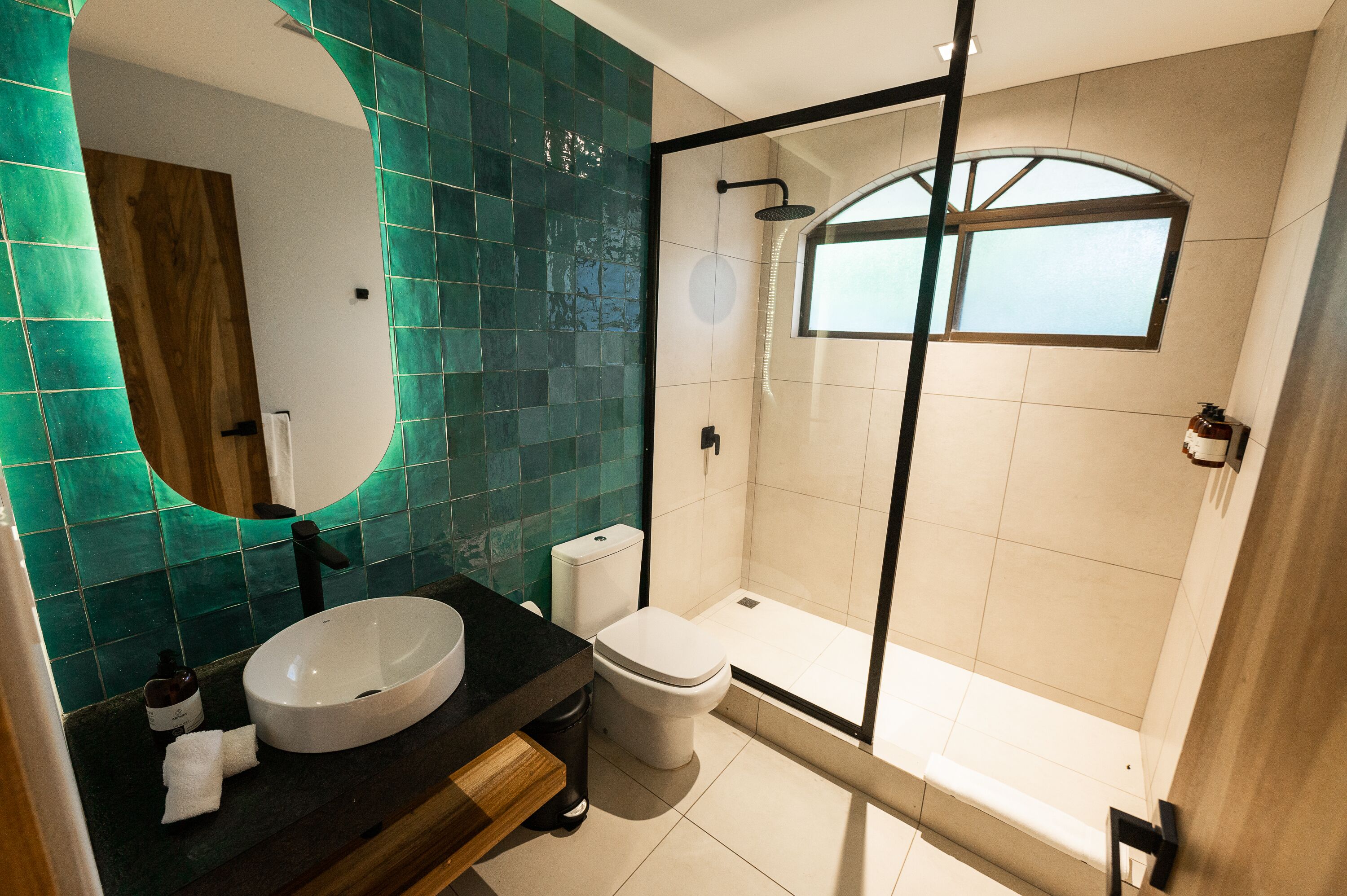 A modern bathroom with a freestanding bathtub, a large mirror, and a sink.