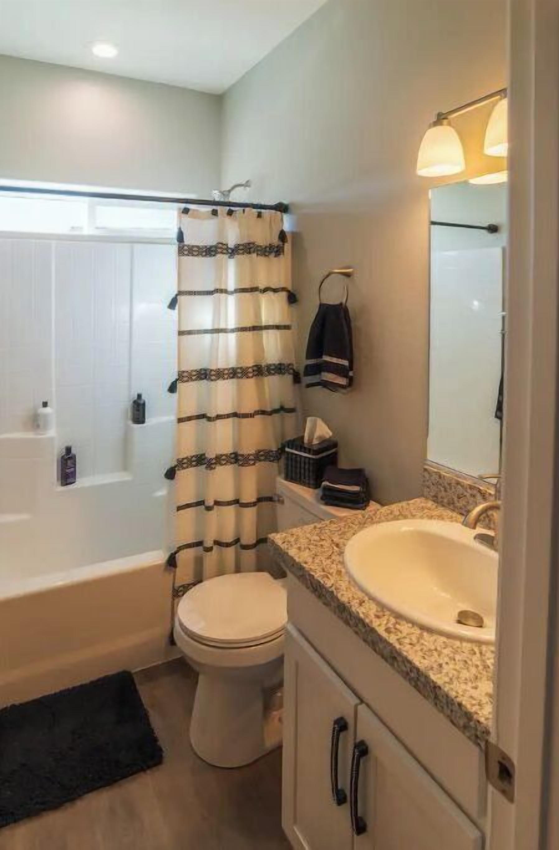 A bathroom with a bathtub, toilet, and sink.