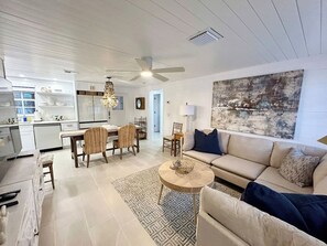 A modern living room with a sofa, coffee table, and dining area.