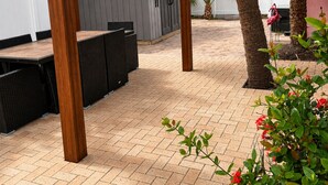 Un espace patio agrémenté d’une pergola, de meubles d’extérieur et d’un petit abri de jardin.