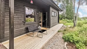 A wooden cabin with a porch, a bench, and a small table. - Beautiful home in Steinsholt with sauna (Steinsholt)