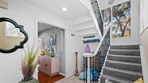 A staircase with a handrail, a wall-mounted sign, and a window with a tree view. - Beautiful Spacious Home in Palmetto Dunes w Pool 5 minute Walk to the Beach ! (Hilton Head Island)