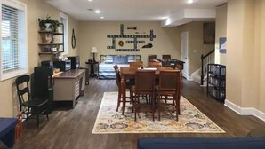 A spacious living area with a dining table, chairs, a kitchen area, and a staircase leading to another level. - Beautiful farm stay apartment, rural Georgetown KY (Georgetown)