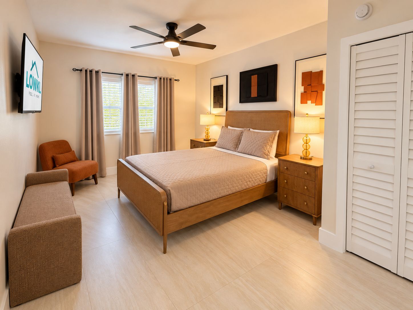 A hotel room with a bed, a chair, a bench, a ceiling fan, a nightstand with a lamp, and a door.