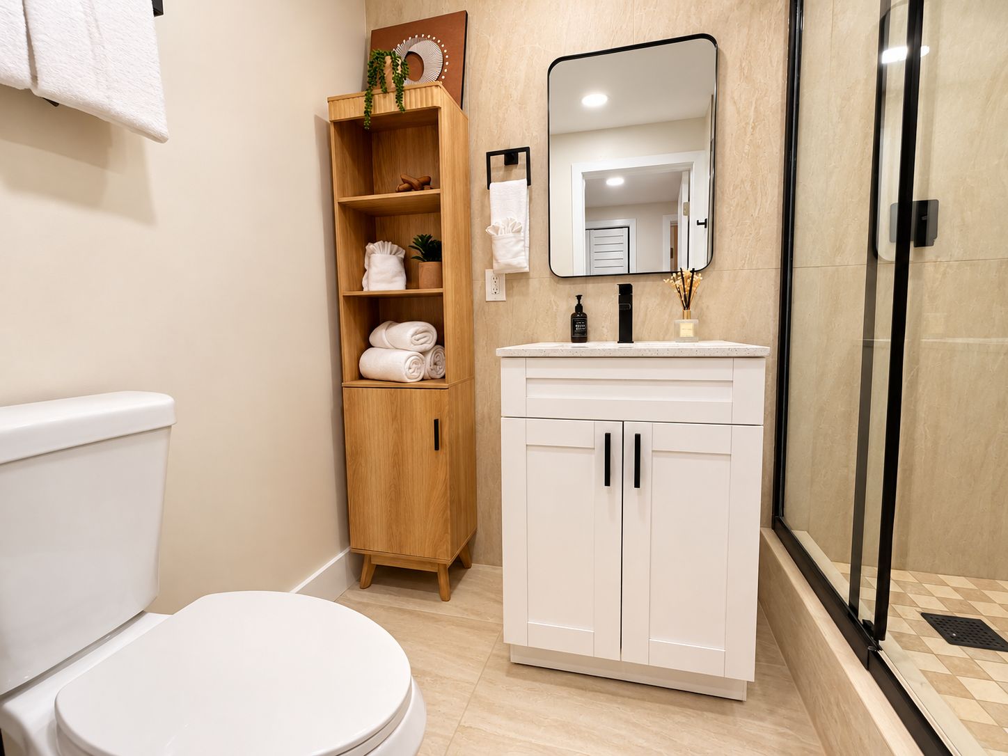 Ein modernes Badezimmer mit Toilette, einem Holzboden mit Handtüchern, einem Spiegel und einer Duschkabine.