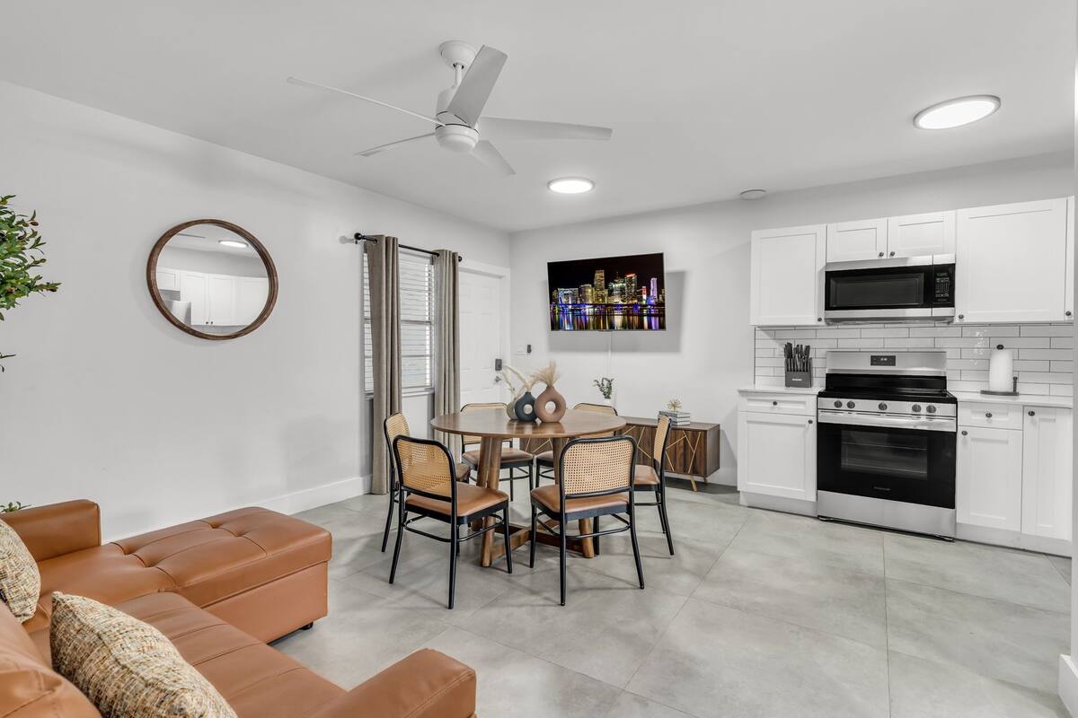 A modern kitchen with white cabinets, a built-in microwave, and an oven.