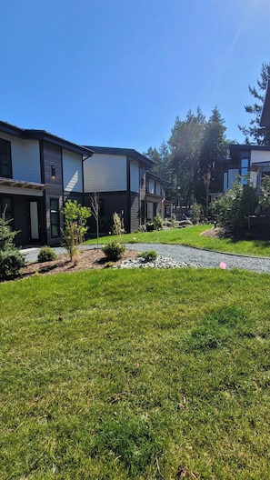 Un immeuble résidentiel moderne doté d’une pelouse et d’un jardin bien entretenus.