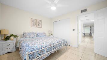 A bedroom with a bed, nightstand, lamp, and wall art.