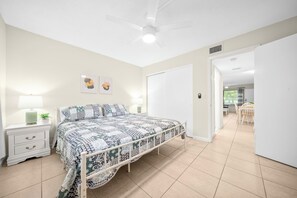 Un dormitorio con cama, mesita de noche y decoración en la pared.
