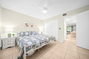 Ein Schlafzimmer mit Bett, Nachttisch und Wandbildern.