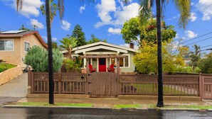 A two-story house with a red door, a covered porch, and a number 3092 on the front.