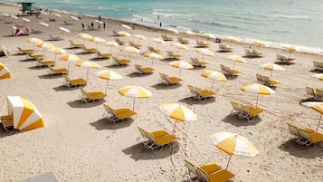 In Strandnähe, weißer Sandstrand, Sonnenschirme, Strandtücher