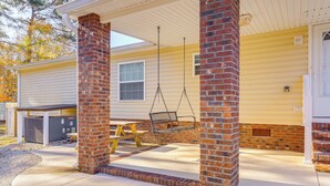 A covered porch with a swing, a picnic table, and a brick column. - Cozy New Bern Getaway < 2 Mi to Trent River! (New Bern)